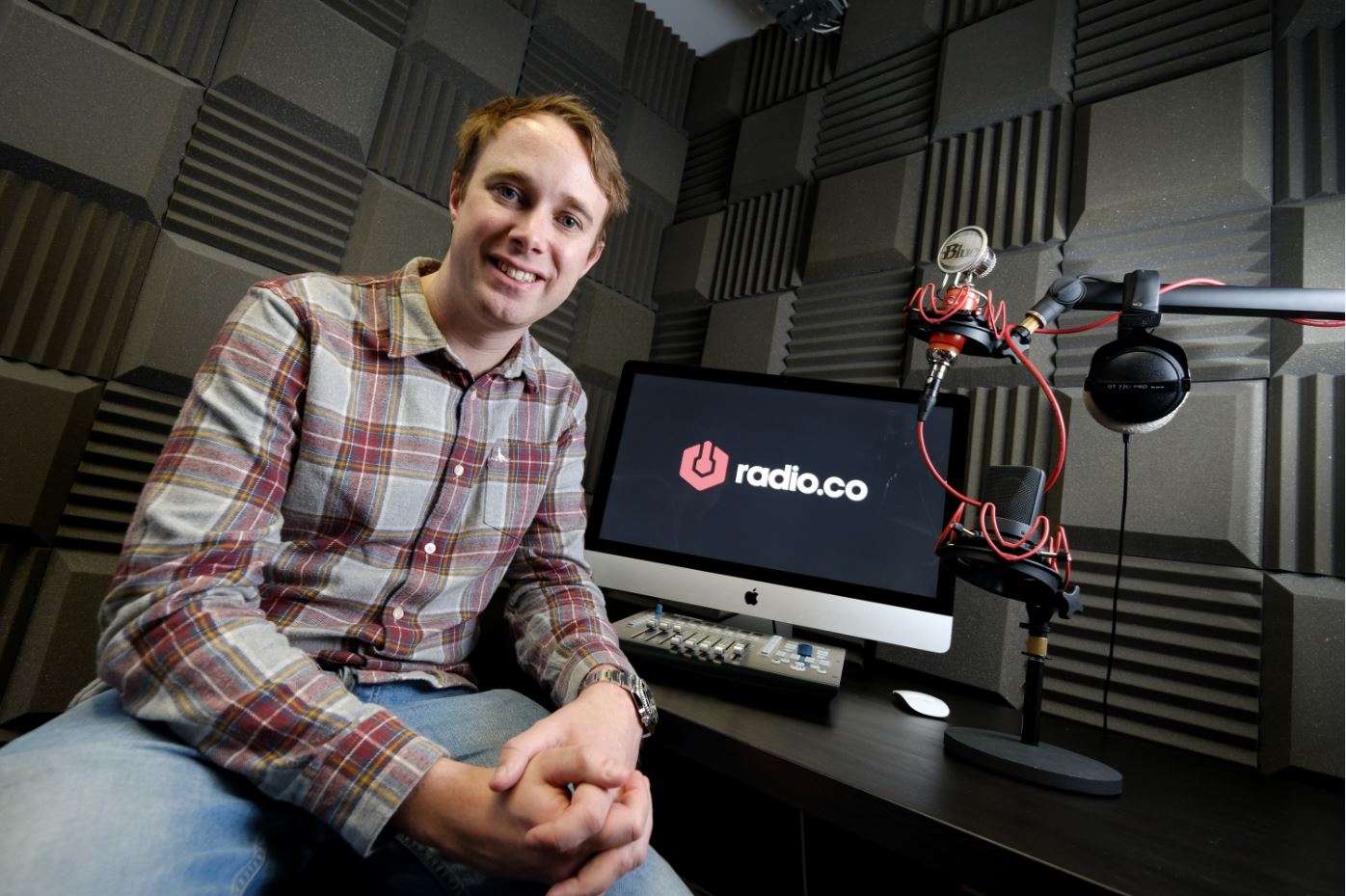 A man from Radio.co sat in a recording studio